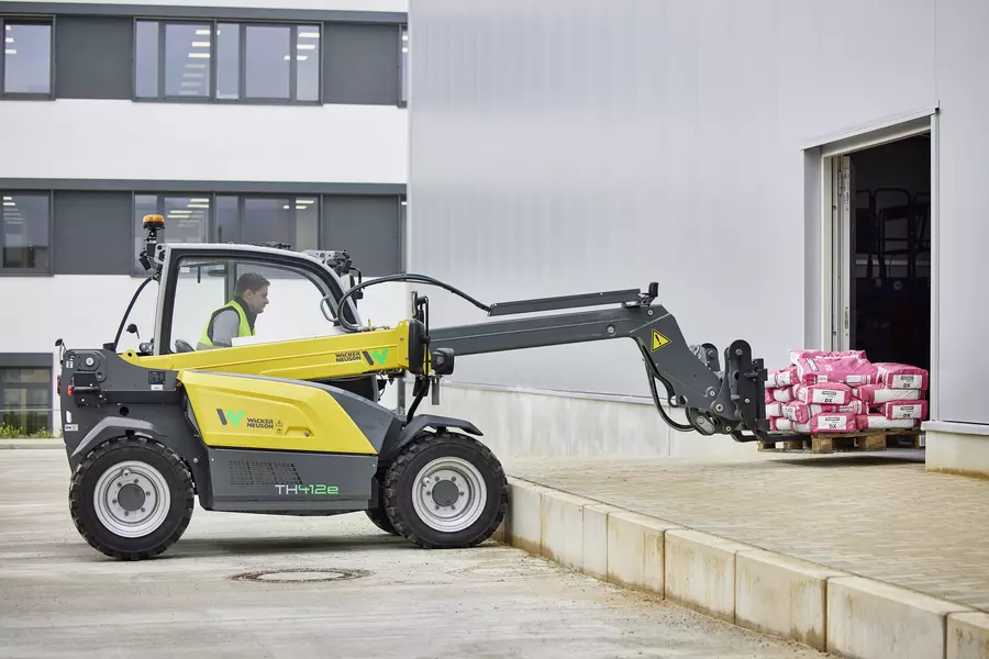 Wacker Neuson TH412e telehandler in use on a construction site with pallet fork