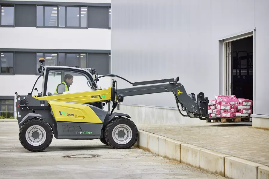 Wacker Neuson TH412e telehandler in use on a construction site with pallet fork