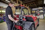 Weidemann telehandler T4512e during loading process on a farm