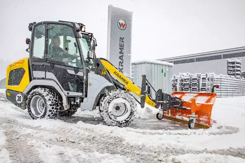 Der Kramer Radlader 5040 beim Schneeschieben in einer Kurvenfahrt. 