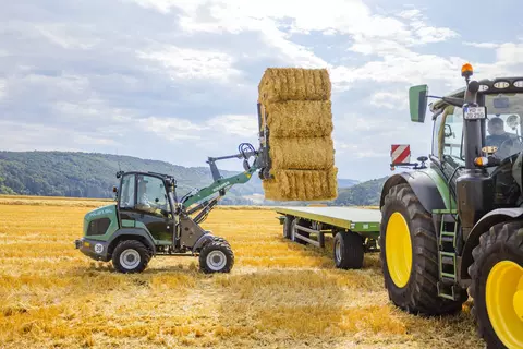 Der Kramer Radlader KL21.5L bei der Arbeit mit Strohballen.
