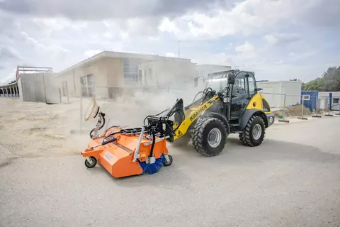 Der Kramer Radlader 5075 mit einer Kehrmaschine.