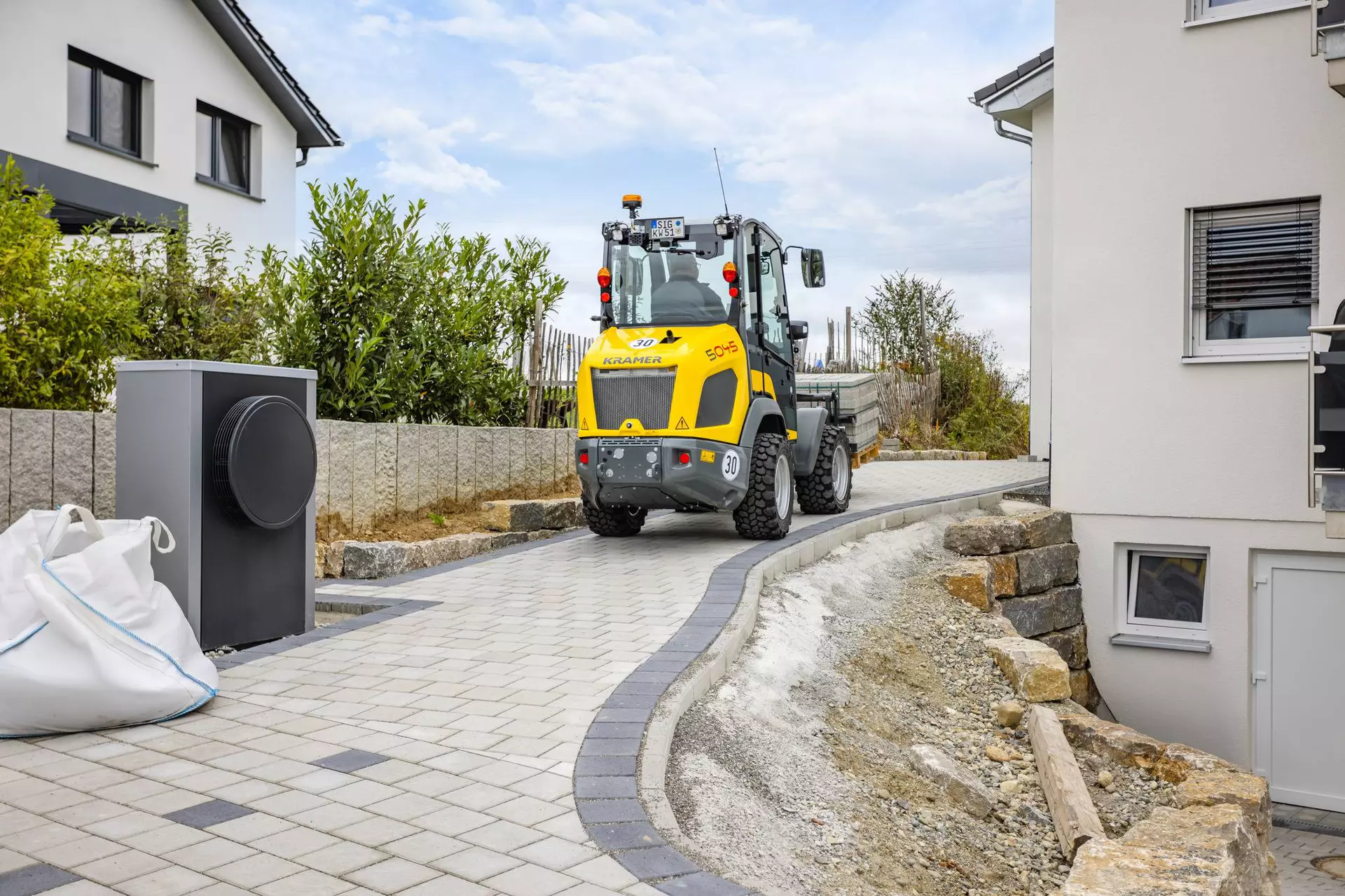 Wheel loader 5045 drives along the pedestrian walkway.