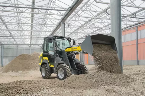 The compact 5040 while pouring out gravel.