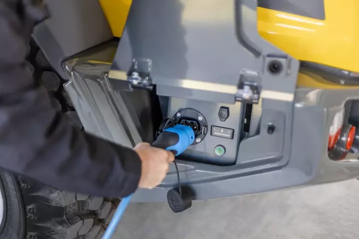 Der vollelektrische Kramer Radlader 5065e beim Ladeprozess.