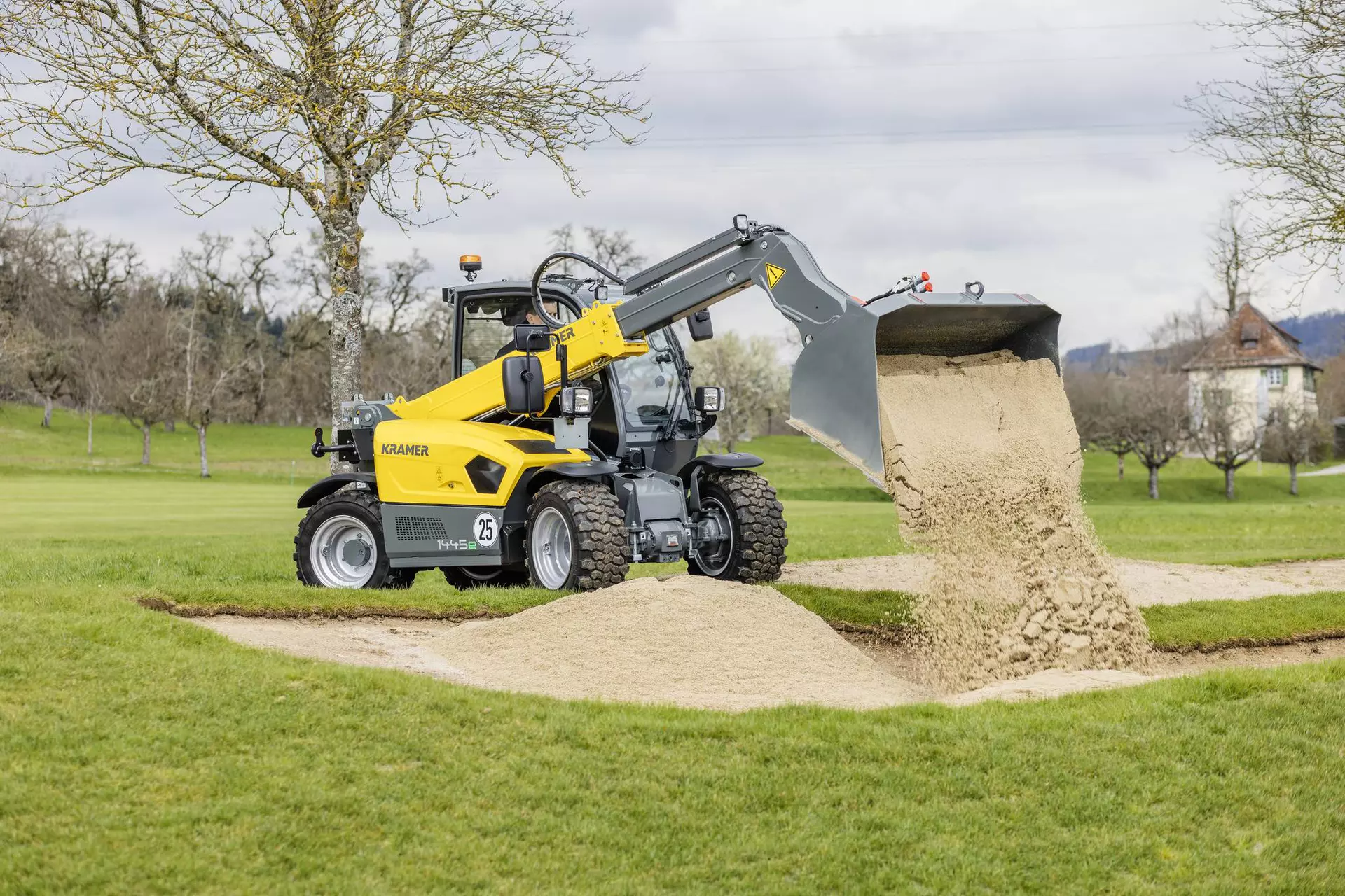 The fully electric Kramer telehandler 1445e while dumping sand.
