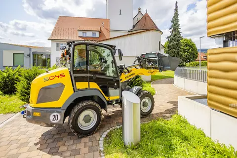 Wheel loader 5045 drives along the pedestrian walkway.