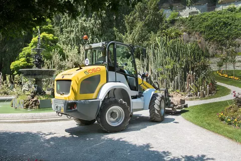 Der Kramer Radlader 5050 beim Transportieren von großen Steinen auf einer Palette.