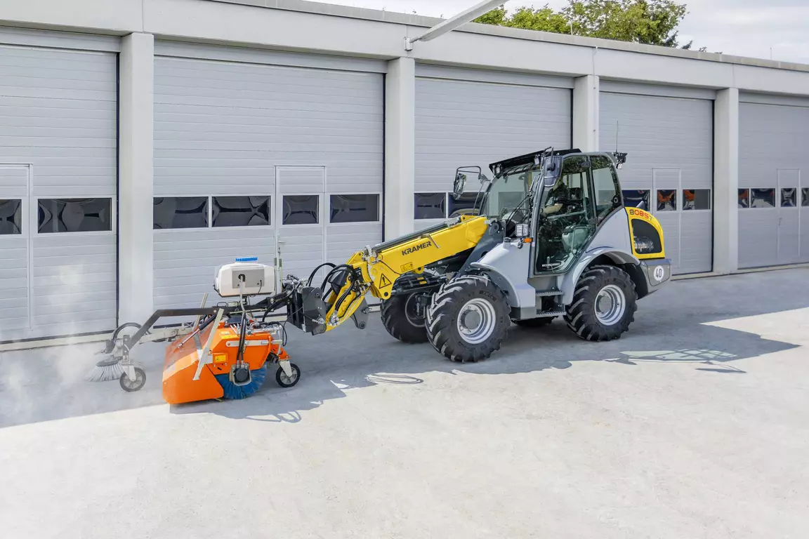 Der Kramer Teleskopradlader 8085T mit einer Kehrmaschine.