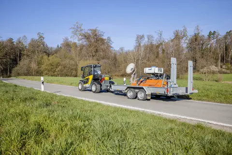 Der vollelektrische Kramer Teleskoplader 1445e beim Fahren mit einem Anhänger.