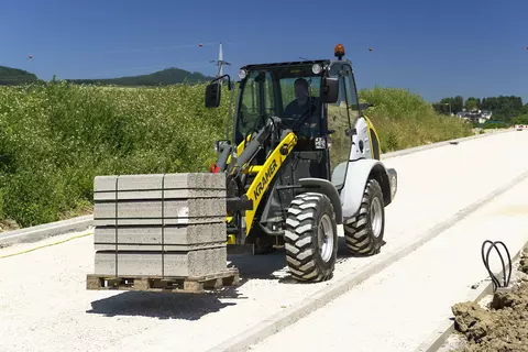Der Kramer Radlader 5085 beim Transportieren eine Steinpalette. 