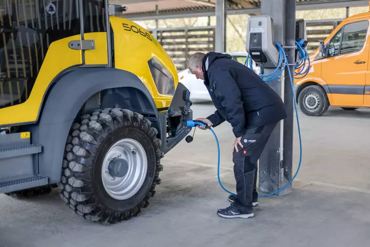 Der vollelektrische Kramer Radlader 5065e beim Ladeprozess.