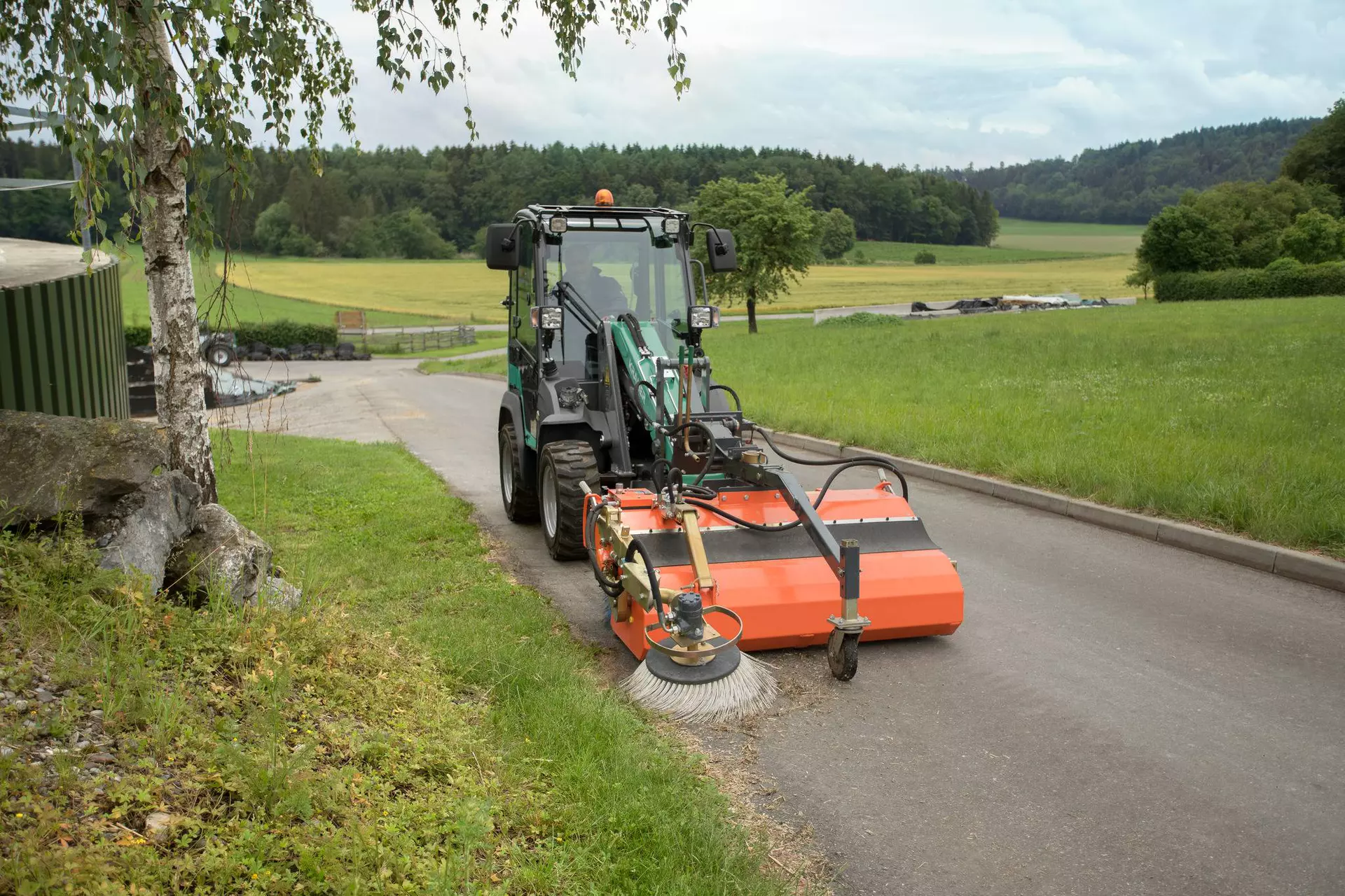 The compact KL12.5 while brushing a yard entrance.