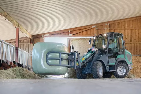 The compact KL14.5 while loading a straw bale with a round bale clamp. 