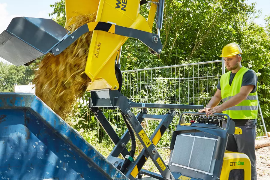 DT10e mit Hochkippmulde beim Abladen von Schutt in einen Container