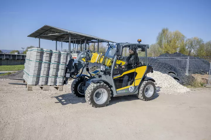 The fully electric Kramer telehandler 1445e while transporting a pallet.