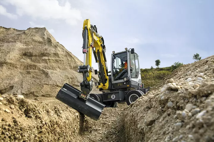Mobilbagger EW65 beim Rohrgrabenaushub im Gelände
