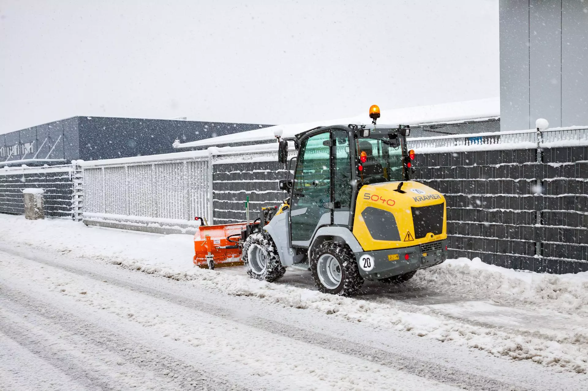 Der Kramer Radlader 5040 beim Schneeschieben auf dem Gehweg. 