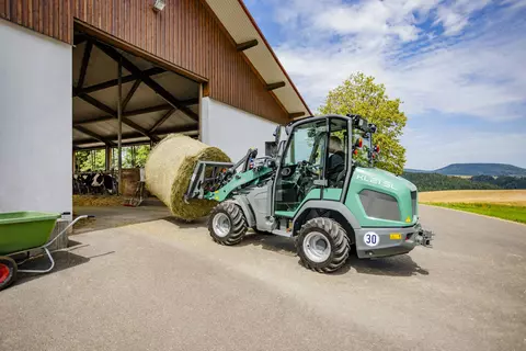 Der Kramer Radlader KL21.5L bei der Arbeit mit Strohballen.