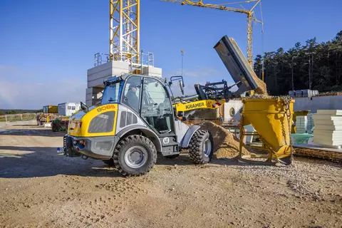 Der Kramer Radlader 8085 beim Ausschütten von Material.