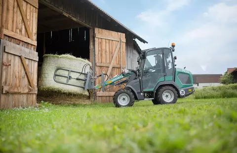 The compact KL14.5 while loading a straw bale through a stable gate. 
