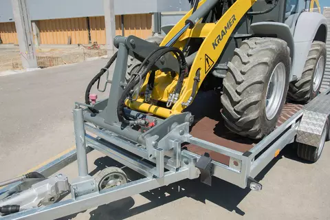Der Kramer Radlader 5050 mit verriegelter Schnellwechselplatte auf einem Anhänger.