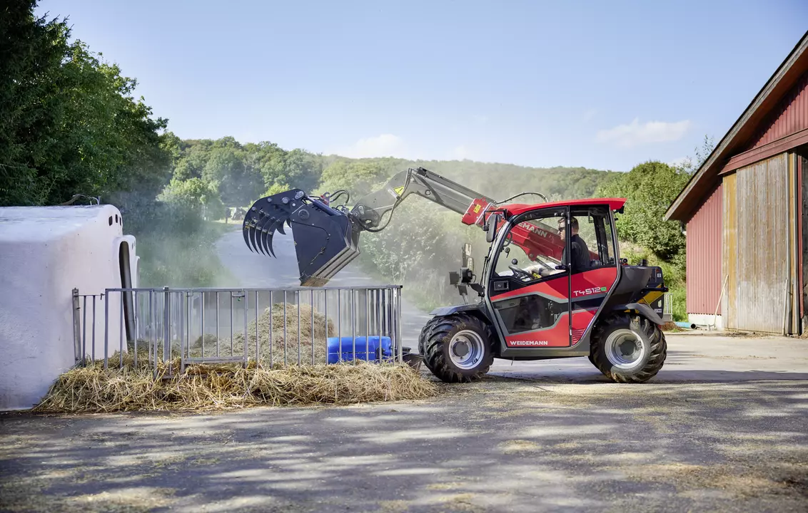 Weidemann T4512e telehandler with gripping bucket in use on a farm