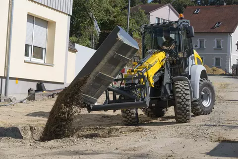 Der Kramer Teleskopradlader 5065T beim Verladen von Erde.
