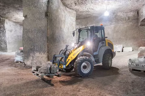 Der Kramer Radlader 5050 beim Transportieren von großen Steinen auf einer Palette. 