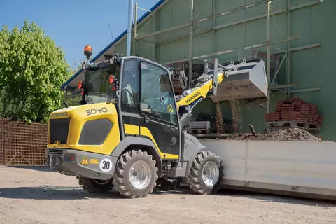 The compact 5040 while loading soil in a container. 