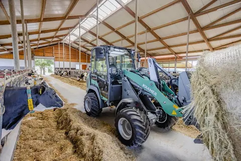 Der Kramer Radlader KL21.5L bei der Arbeit mit Strohballen.