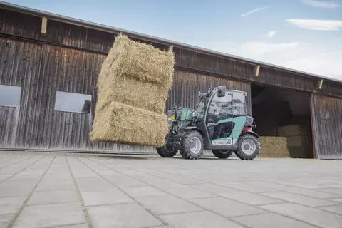 The compact Kramer telehandler KT144 while handling straw.
