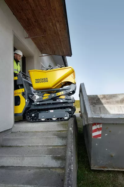 DT08 fährt durch eine Türe um Bauschutt abzuladen