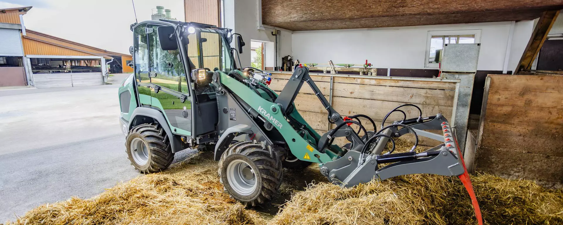 The Kramer KL21.5L wheel loader at work with straw bales.