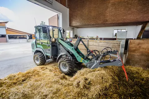 Der Kramer Radlader KL21.5L bei der Arbeit mit Strohballen.