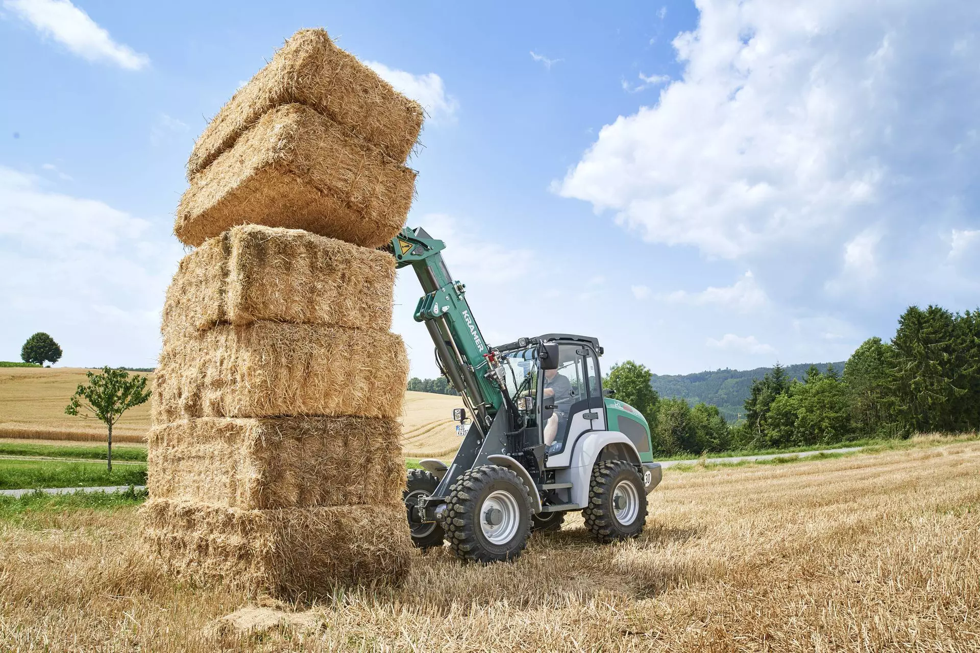 The Kramer telescopic wheel loader KL25.5T while stacking straw on a field. 