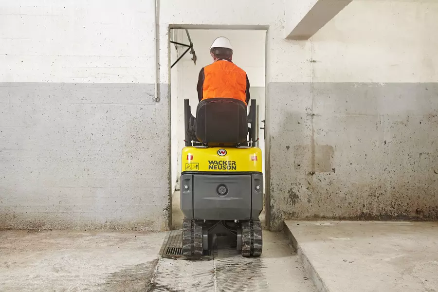 803 Minibagger fährt durch einen schmalen Eingang