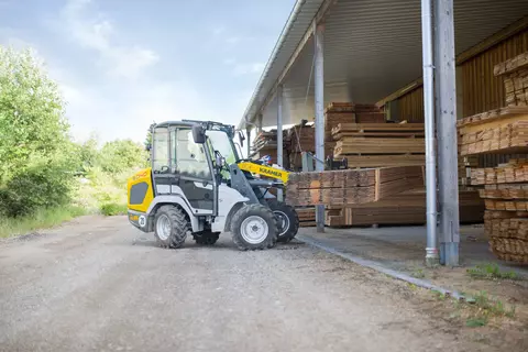 Der kompakte 5040 beim Platzieren von Holz.  