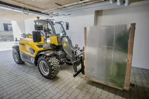 The fully electric Kramer telehandler 1445e while transporting a pallet.