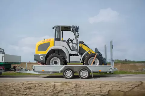 Der Kramer Radlader 5050 beim Transport auf einem Anhänger.