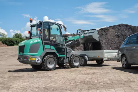 The compact KL12.5 while loading compost on a trailer.