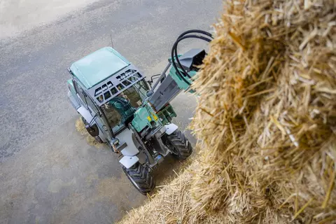 Der Kramer Teleskopradlader KL33.8T beim Stapeln von Stroh. 