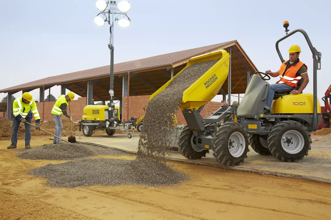 Wheel dumper 1001 unloading gravel on a construction site that is illuminated with a light tower LTN6